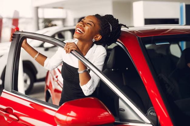 A driver stepping out of her car and smiling